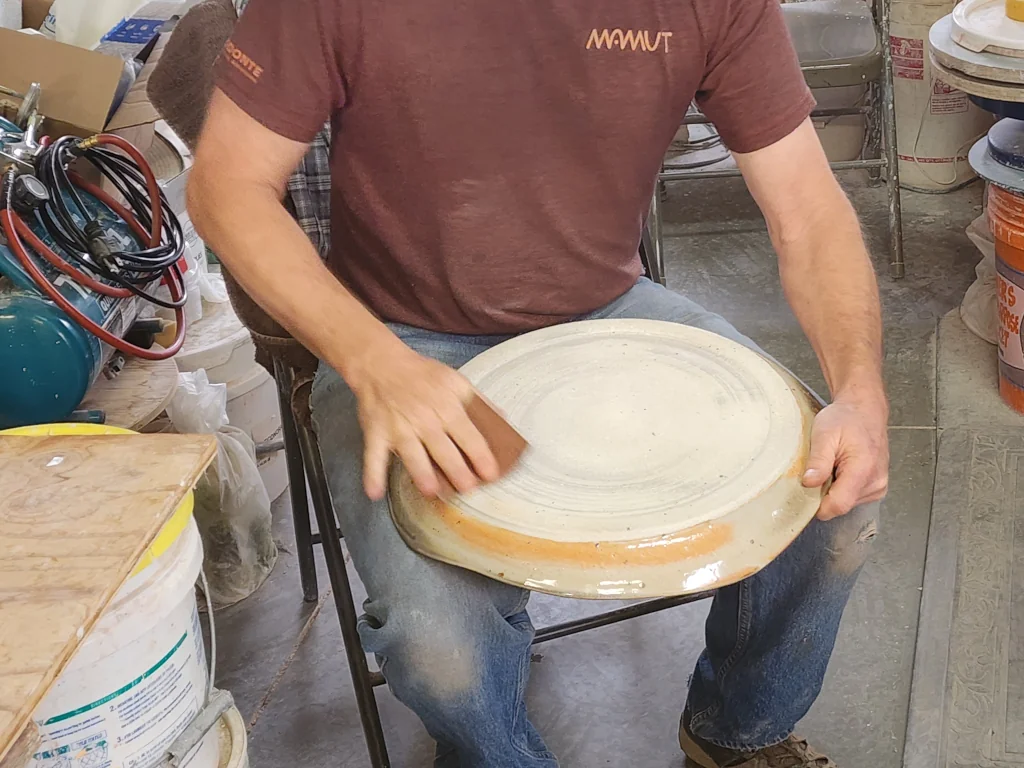Sanding a ceramic plate in process