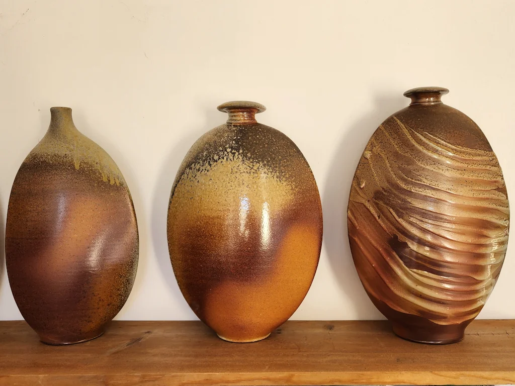 Three ceramic vases on a shelf